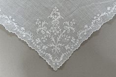 an embroidered white handkerchief on a gray background