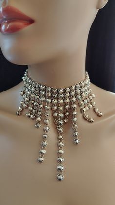 *This unique necklace is a statement piece that will make you stand out from the crowd. It is made of small circular metal pieces that are arranged in a cascading pattern.  *The metal pieces are gold in color and have a shiny finish.  *The necklace has a choker style with a long drop in the center.  *The necklace is adjustable in length and has a lobster clasp closure.  *This necklace is handmade with care and attention to detail. It will add a modern and edgy flair to your look. Metal Choker For Party, Round Metal Choker For Party, Silver Choker With Round Beads For Party, Metallic Party Necklaces, Silver Beads Metal Chain Necklace For Parties, Metal Round Choker For Party, Party Metal Jewelry With Ball Chain, Party Metal Necklace With Ball Chain, Metal Ball Chain Jewelry For Party