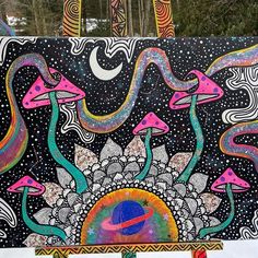 an art work is displayed in front of some trees and snow covered ground with colorful designs on it