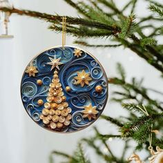 a christmas ornament hanging from a tree with gold stars on it's ornaments