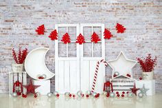 christmas decorations are arranged in front of a brick wall with red and white stars on it