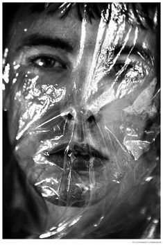 a black and white photo of a man wrapped in plastic