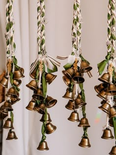 several bells hanging from ropes with ribbons on them