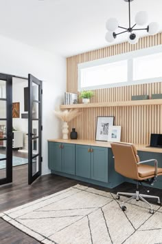 a home office with wood paneling and blue cabinets, along with a rug on the floor