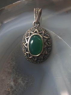 Beautiful green jade pendant in sterling silver. This vintage pendant features an antique style design with en cabachon cut green jade in bezel setting placed in the middle. It would make a lovely addition to every jewelry collection. Length: 3 cm The item remains in very good vintage condition.  Hallmarked for sterling silver. For your own impression, review the pictures pictures carefully prior to making a purchase. Any wear is part of character. Matching earrings available. https://koorboutiq Vintage Jewelry Pendant With Stone Setting, Vintage Pendant Jewelry With Stone Setting, Vintage Green Oval Cabochon Jewelry, Green Pendant Jewelry With Stone Setting, Green Stone Setting Pendant Jewelry, Silver Jade Oval Pendant Jewelry, Antique Green Oval Jewelry, Green Pendant Necklace With Stone Setting, Green Sterling Silver Medallion Jewelry