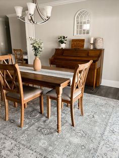 a dinning room table with chairs and a piano in the backround area