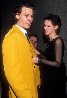 a man in a yellow suit standing next to a woman