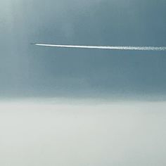 an airplane is flying in the sky leaving a trail