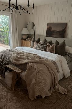 a bedroom with a bed, dresser and chandelier in it's center