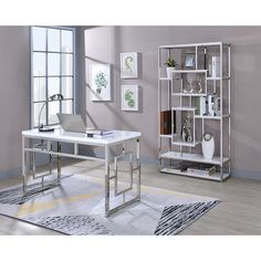 a white desk sitting in front of a window next to a book shelf filled with books