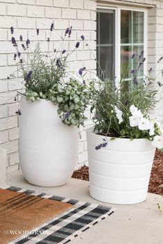 two large white planters sitting on top of a porch