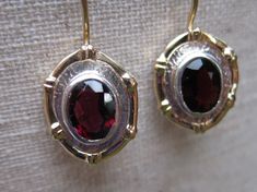 Stunning red Garnet Earrings with 14k solid Gold frame and 14k solid Gold .8 mm ear wires.  Finished with safety clasp so you'll never lose this precious pair.  The  Garnet gemstones measure 8 x 6 mm.  The gemstones sit in a  Sterling Silver oval frame for the finishing touch.   Garnet is a spiritual stone of self-empowerment.  This gemstone imbues the owner with strength, safety and prosperity.   Garnet is the January birthstone and the gemstone that celebrates the two year marriage anniversary. Elegant Red Earrings With Polished Finish, Yellow Gold Garnet Round Earrings, Red Polished Fine Jewelry Earrings, Oval Garnet Gemstone Earrings, Red Polished Finish Fine Jewelry Earrings, Elegant Red Jewelry With Bezel Setting, Elegant Oval Garnet Earrings, Red Polished Earrings For Gift, Formal Garnet Jewelry With Bezel Setting