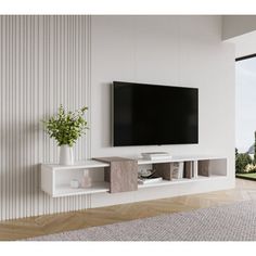 a white entertainment center with a flat screen tv mounted on it's side, in front of a sliding glass door