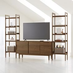 an entertainment center with shelves and a flat screen tv on it's stand in a white room