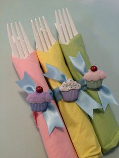 four napkins with cupcakes on them are sitting next to each other in different colors