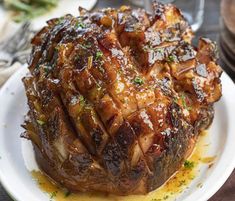 a close up of a meat on a plate with sauce and garnishes