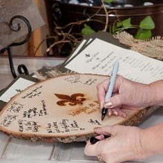 a person writing on a piece of wood