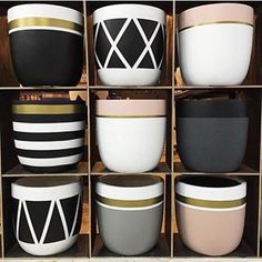 several black and white bowls are stacked on shelves