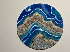 a blue and gold plate on a white wall with glitters in the middle,