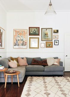 a living room filled with furniture and pictures on the wall above it's couch