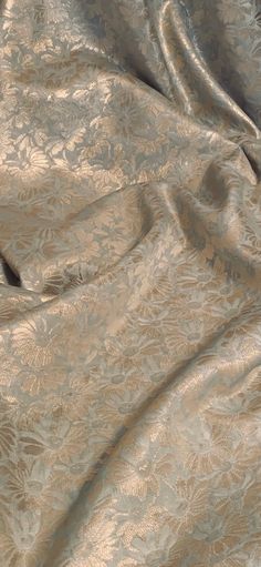 the fabric is very soft and shiny with some flowers or leaves on it's surface