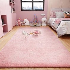 a bedroom with pink walls and flooring in the room is furnished with toys, bookshelves, and stuffed animals