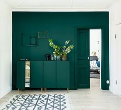 a living room with dark green walls and white flooring on the carpet, along with an area rug