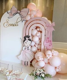 a table with balloons, cupcakes and cake on it at a ballerina themed birthday party