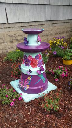 a purple and white flower pot with butterflies on it