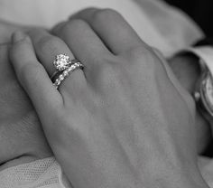 a man and woman holding each other's hands with their wedding rings on them