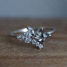 an engagement ring with three pear shaped diamonds on the top and one pear shaped diamond in the middle