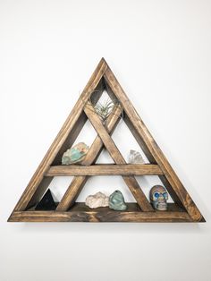 a wooden triangle shelf with rocks and air plants