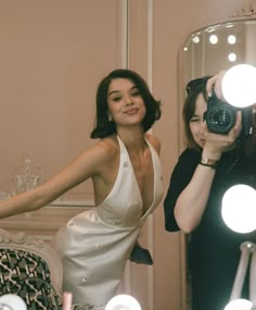 a woman taking a selfie in front of a mirror with lights on the floor