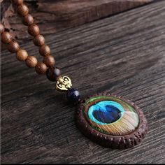 This Exquisite Vintage Wood Pendant Necklace Features A Mesmerizing Blue-Green Peacock Feather Design, Carefully Encased In A Round Wooden Frame. The Pendant Is Suspended From A Sturdy Brown Wooden Beaded Chain, Adding A Touch Of Elegance To This Unique Piece. The Necklace Is Not Only A Fashionable Accessory But Also A Meaningful Symbol Of Beauty And Renewal, Making It A Perfect Gift For Yourself Or Someone Special. Vintage Wood Pendant Necklace Blue-Green Peacock Feather Design Wooden Beaded Chain Elegant And Meaningful Accessory Perfect Gift For Any Occasion Peacock Feather Pendant, Peacock Feather Design, Green Peacock, Feather Pendant, Feather Design, Wood Pendant, Necklace Blue, Macrame Jewelry, Peacock Feather