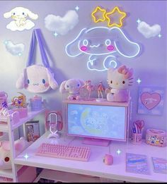 a desk with a keyboard, monitor and stuffed animals on it in a room filled with toys