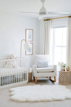 a baby's room with a white crib, rocking chair and window