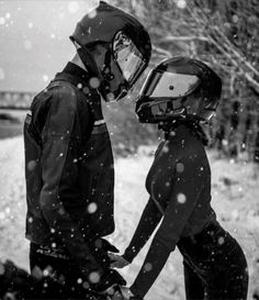 two people wearing helmets walking in the snow