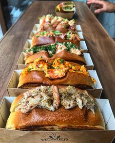 a long wooden table topped with lots of sandwiches and other food on top of it