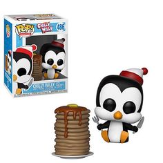 a penguin with a red hat is next to a stack of pancakes and a pop vinyl figure