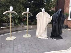 three mannequins dressed in black and white robes