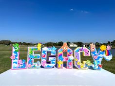 there is a large sign that says happy on the top of a white table in front of some water