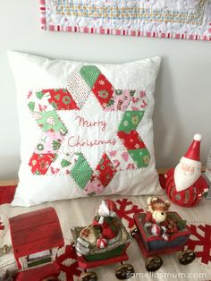 a santa clause pillow sitting on top of a bed next to other christmas decorations and toys