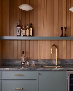 a kitchen with marble counter tops and gold faucet pulls on the cabinet doors