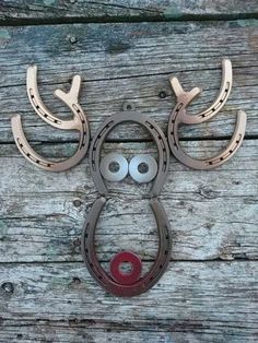 a metal deer head with horns and eyes on wooden planks, next to a pair of scissors