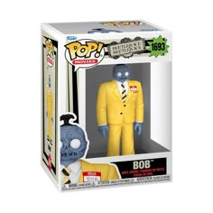 a pop vinyl figure in a yellow suit and tie with an alien head on it