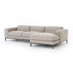 a white couch with a chaise lounger on the bottom right side and an ottoman in the middle