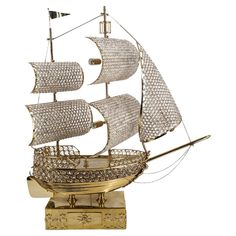 a metal model of a sailing ship on a white background