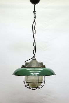 a green light hanging from a metal chain