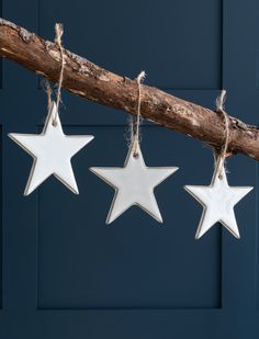 three white stars hanging from a tree branch