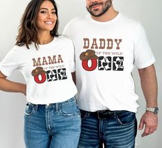 a man and woman standing next to each other wearing matching tshirts that read,'daddy of the wild one '